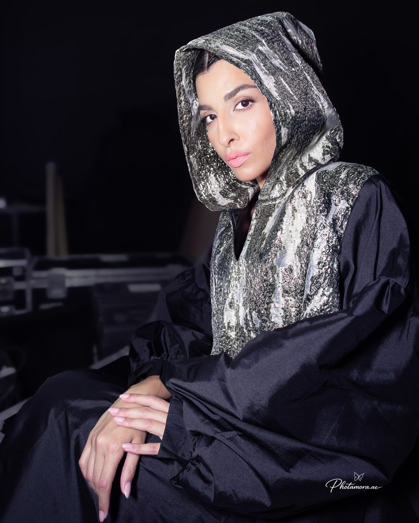 Model in a metallic hooded cape